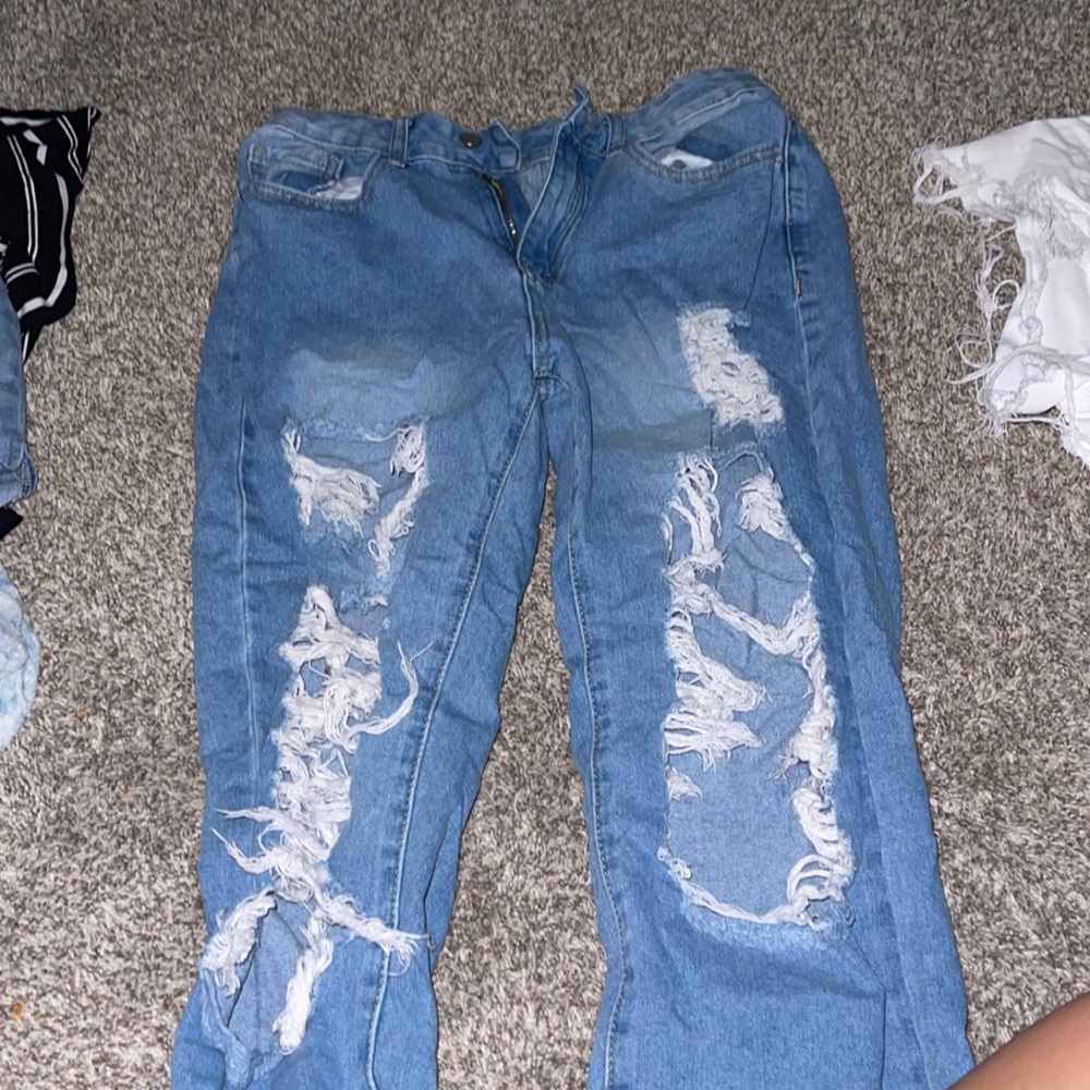Blue jeans, holes in the front. Large but fits small. Not stretchy